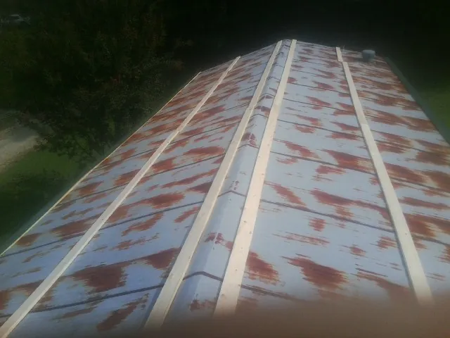Rusted metal roof panels with new wood purlins before replacement — Storm Damage Roof Repair in Halsey by Roofing Brothers
