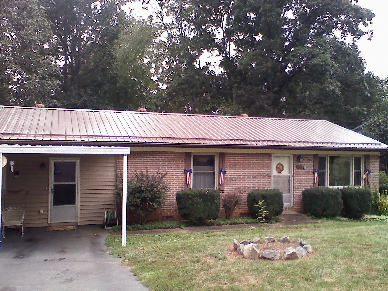 Bronze metal roof and carport on a brick ranch home — Roof Repair work by our crew in Halsey